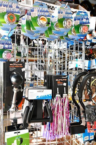 A bunch of bicycle parts are hanging on a rack in a store.
