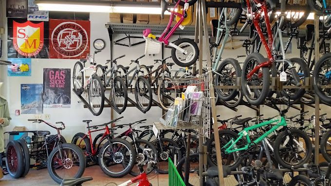 A bicycle store filled with lots of bicycles hanging on the wall.