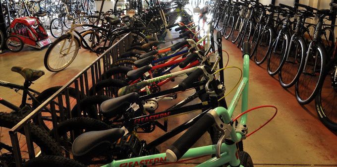 A row of bicycles are lined up in a store.