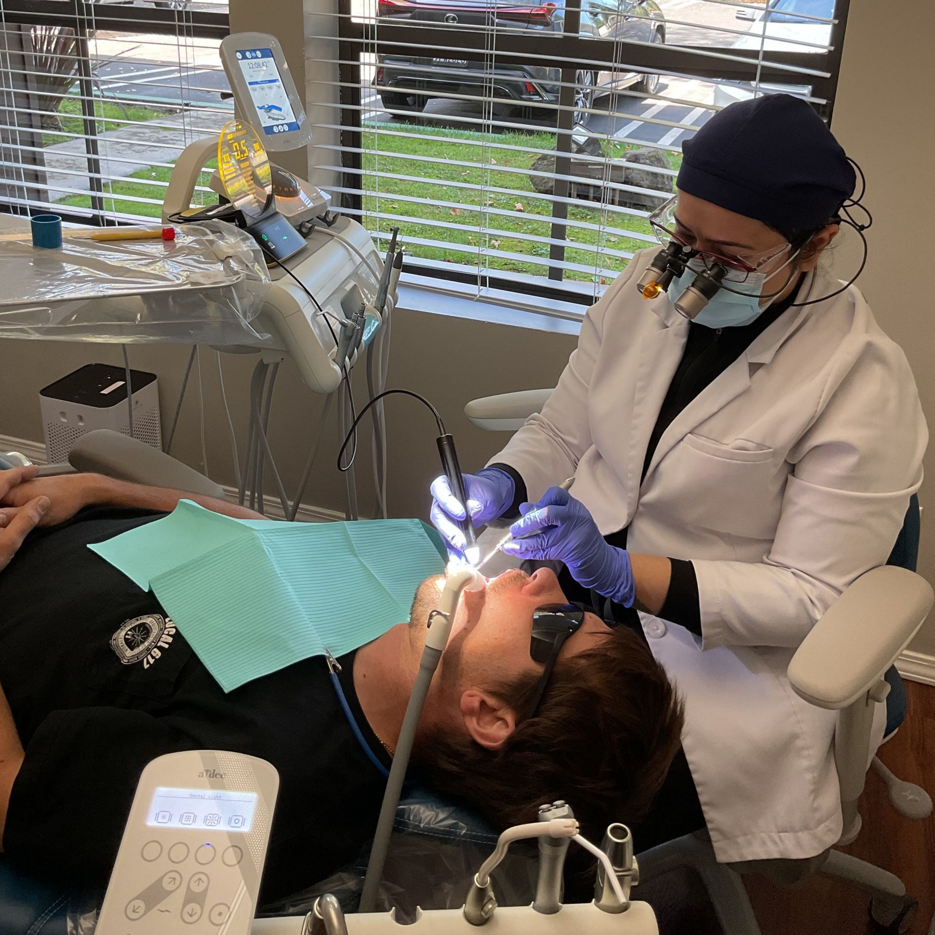 A woman is sitting in a dental chair and smiling.