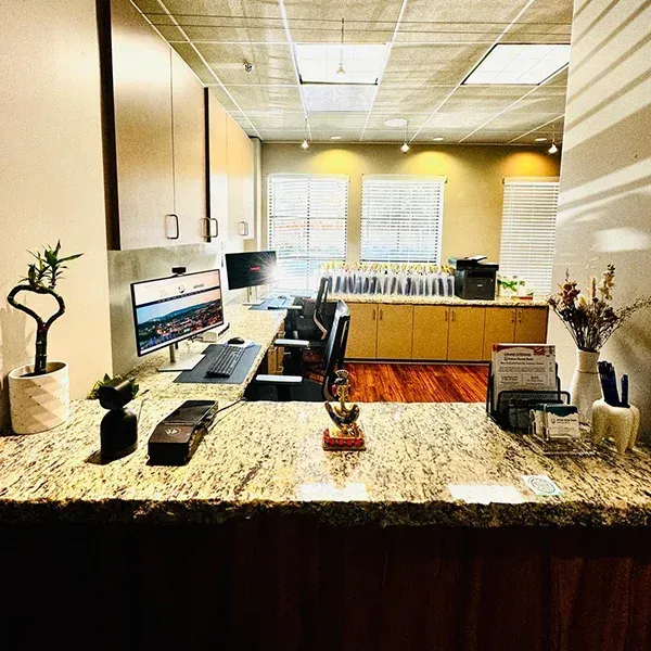 A desk with a computer and a printer on it