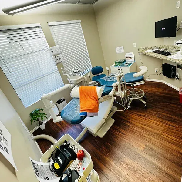 A dental office with a dental chair and a computer