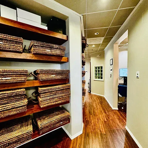 A hallway with wicker baskets on the shelves