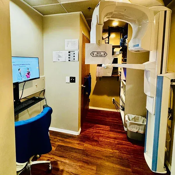 A dental office with a computer and a chair