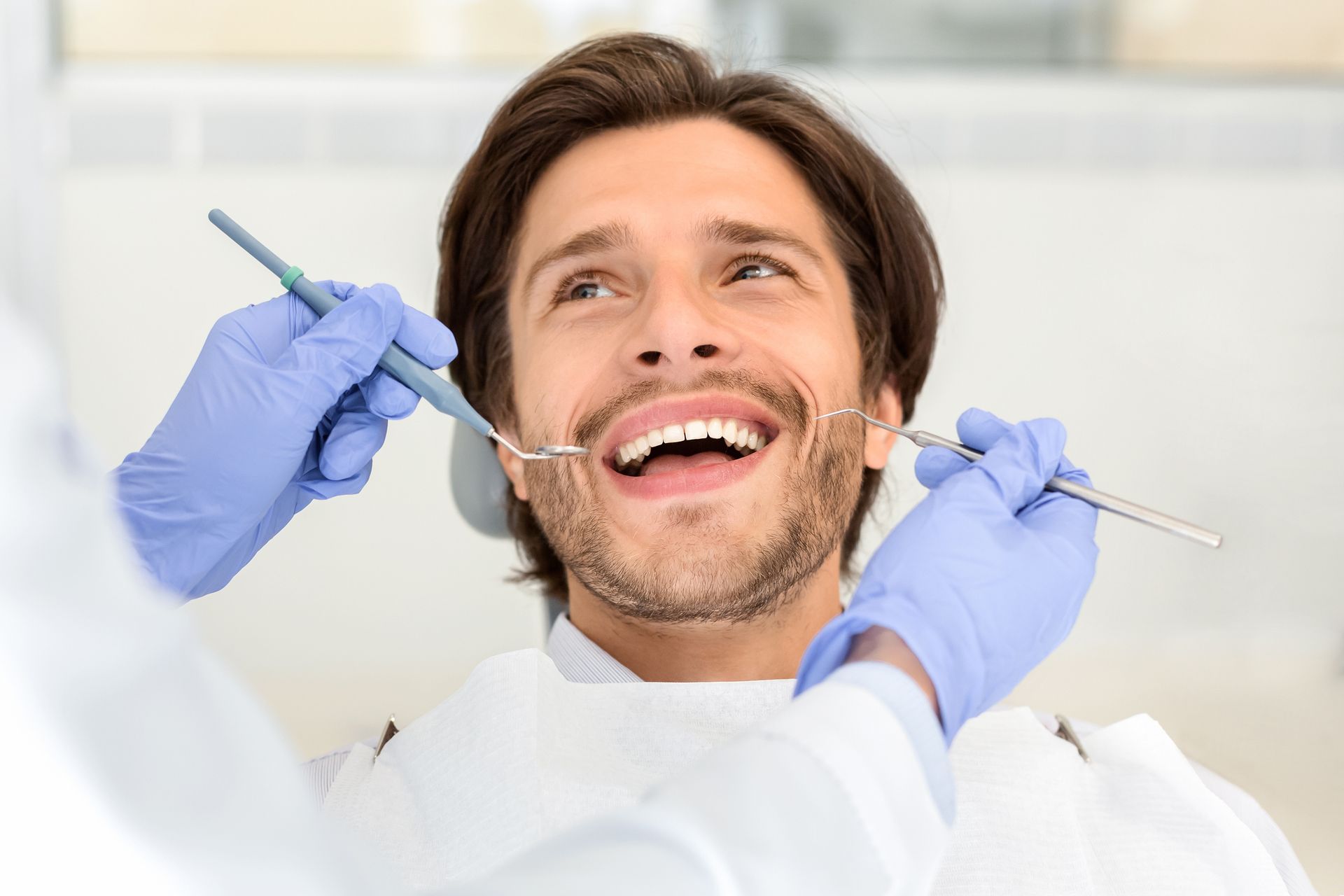 A dentist is working on a patient in a dental chair