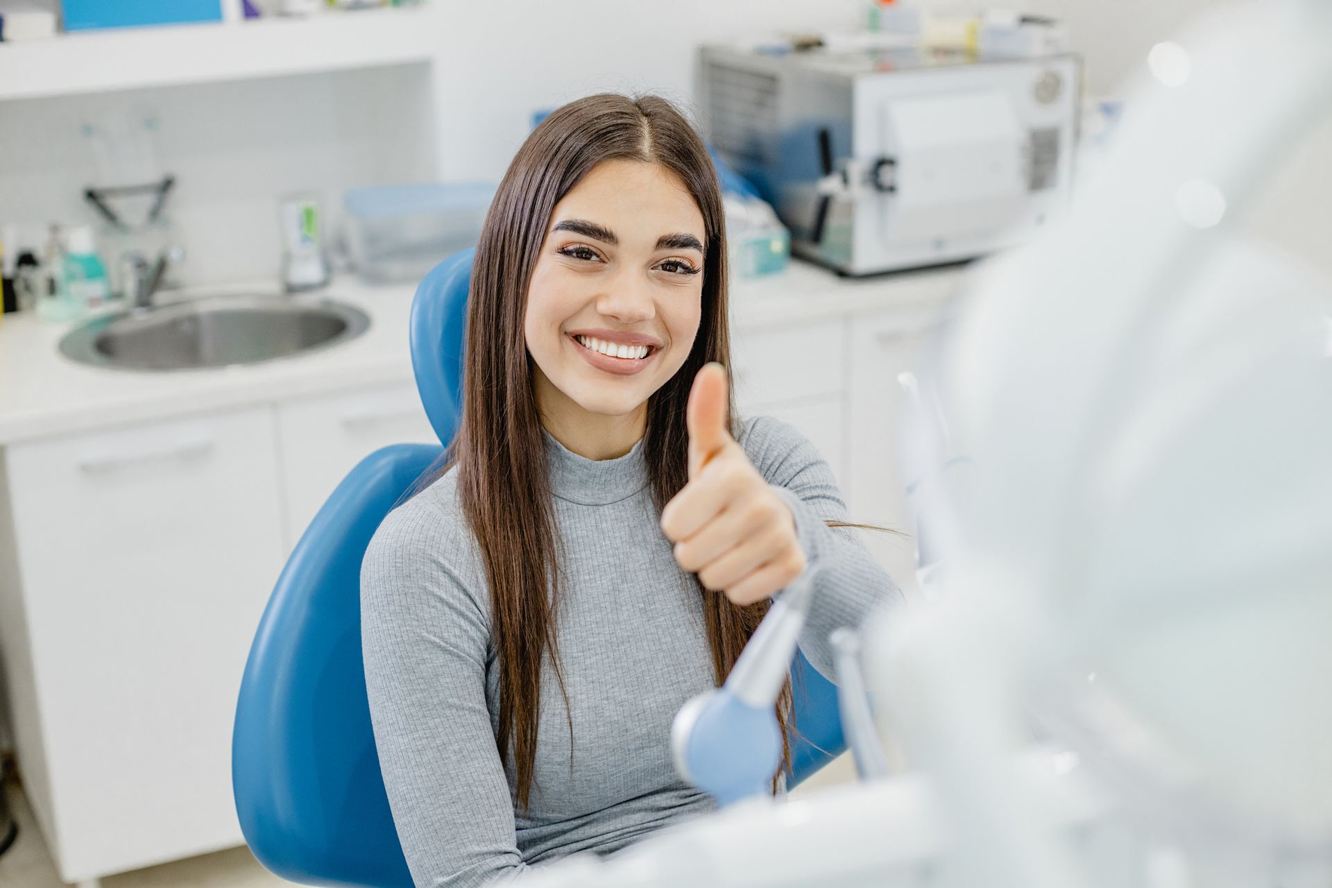 A dentist is working on a patient in a dental chair