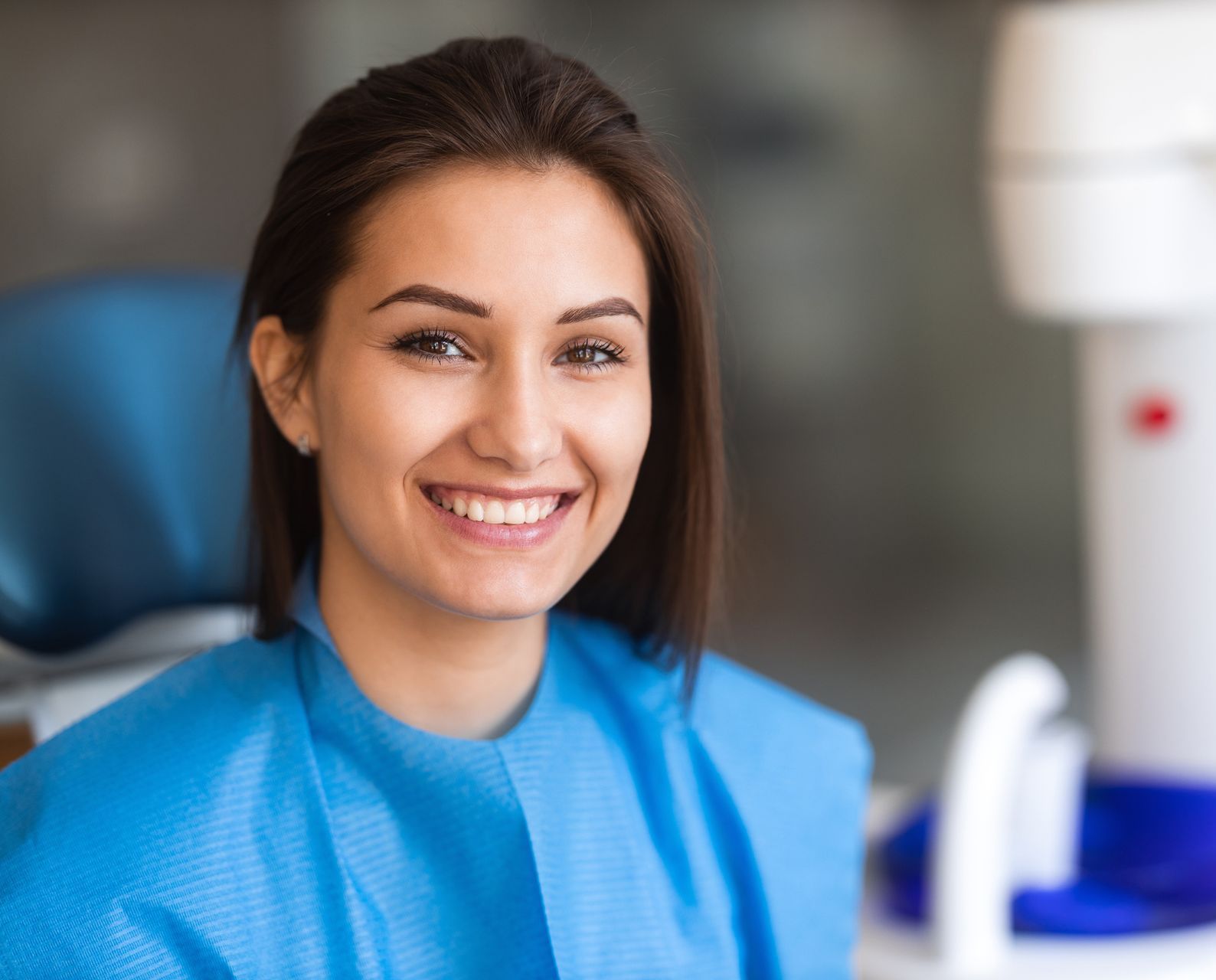 A dentist is working on a patient in a dental chair