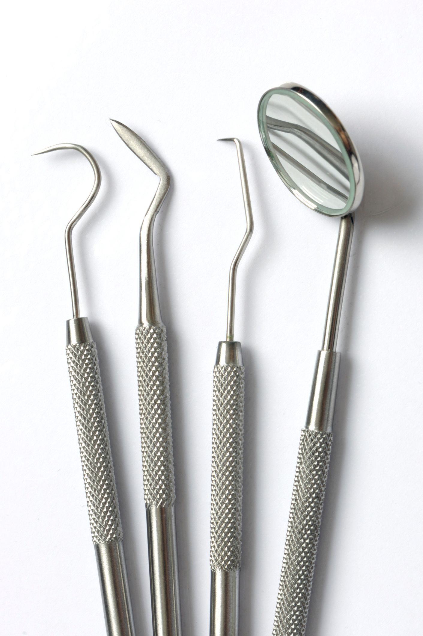 A set of dental instruments on a white surface