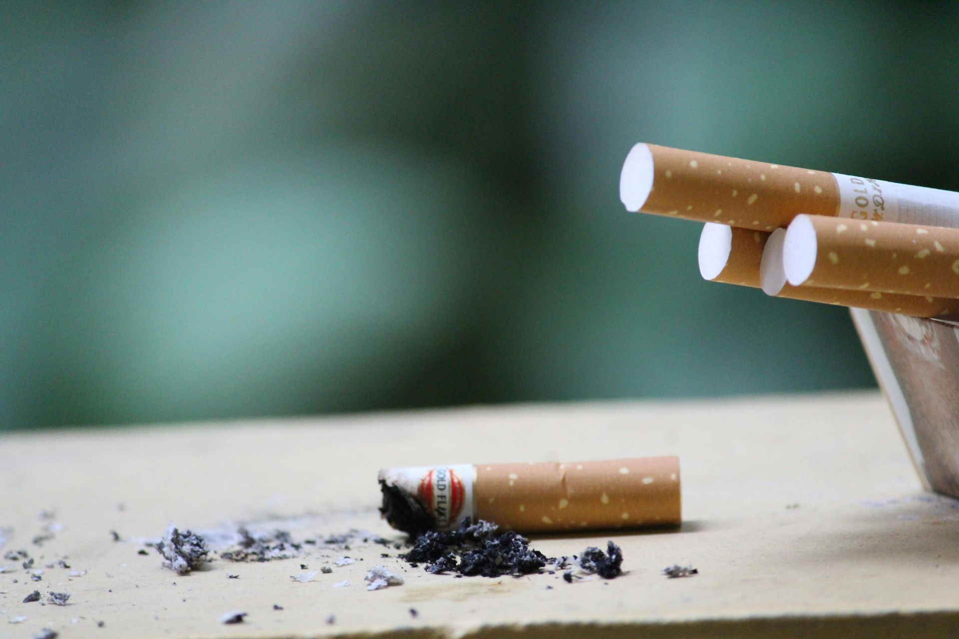 A stack of cigarettes sitting on top of an ashtray on a table.