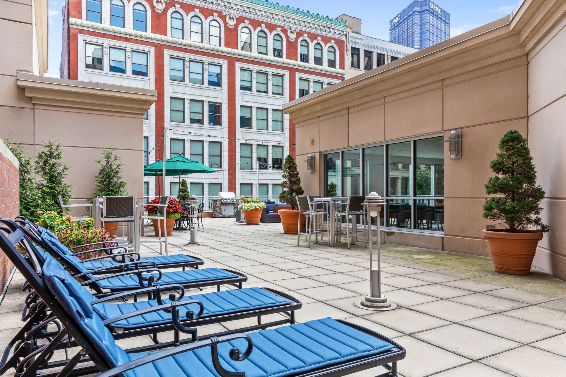 A row of blue lounge chairs on a patio in front of a building