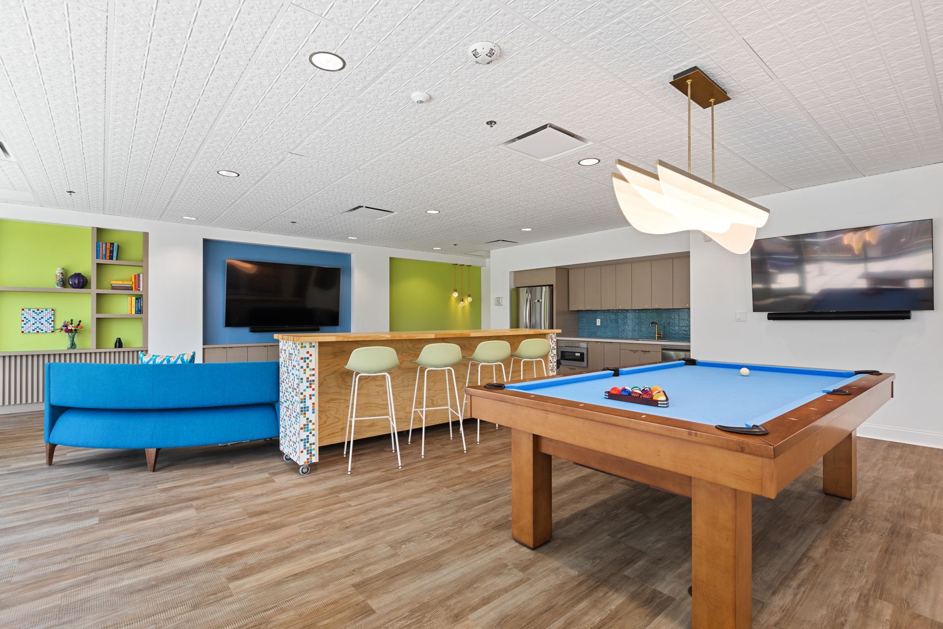 A pool table in a living room with a blue couch