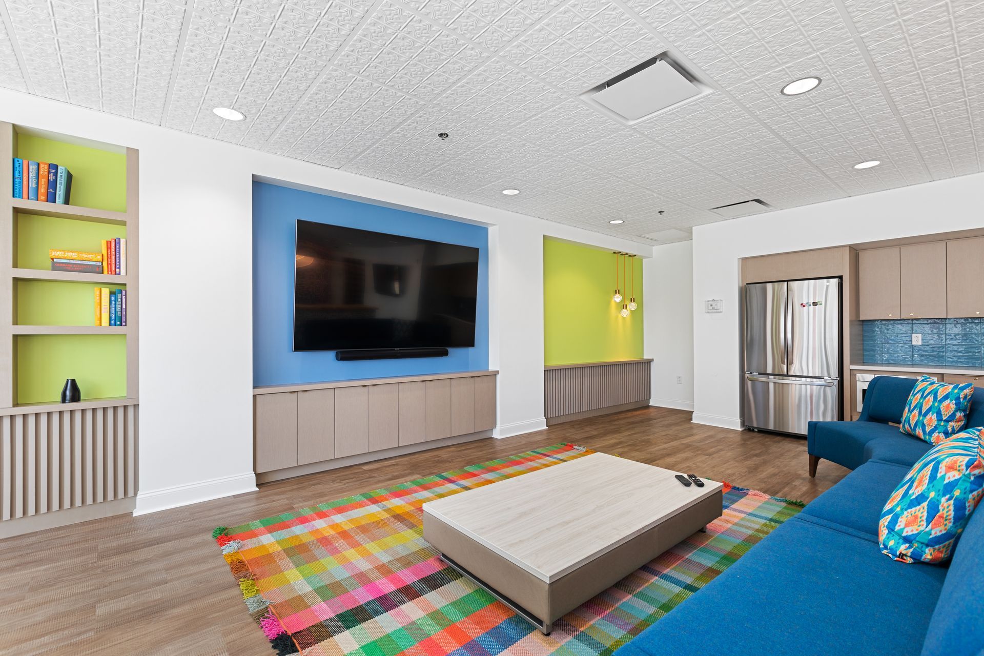 A living room with a blue couch and a flat screen tv
