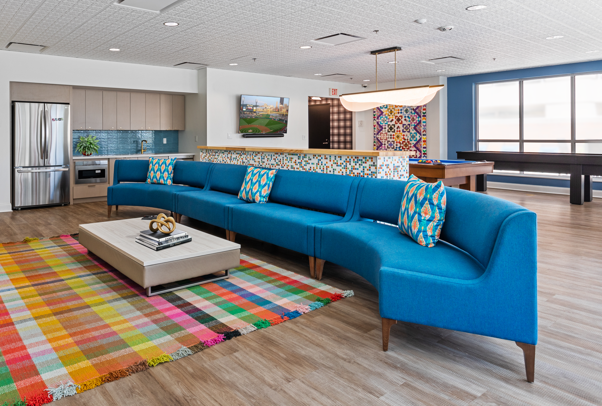 A living room with blue couches and a pool table