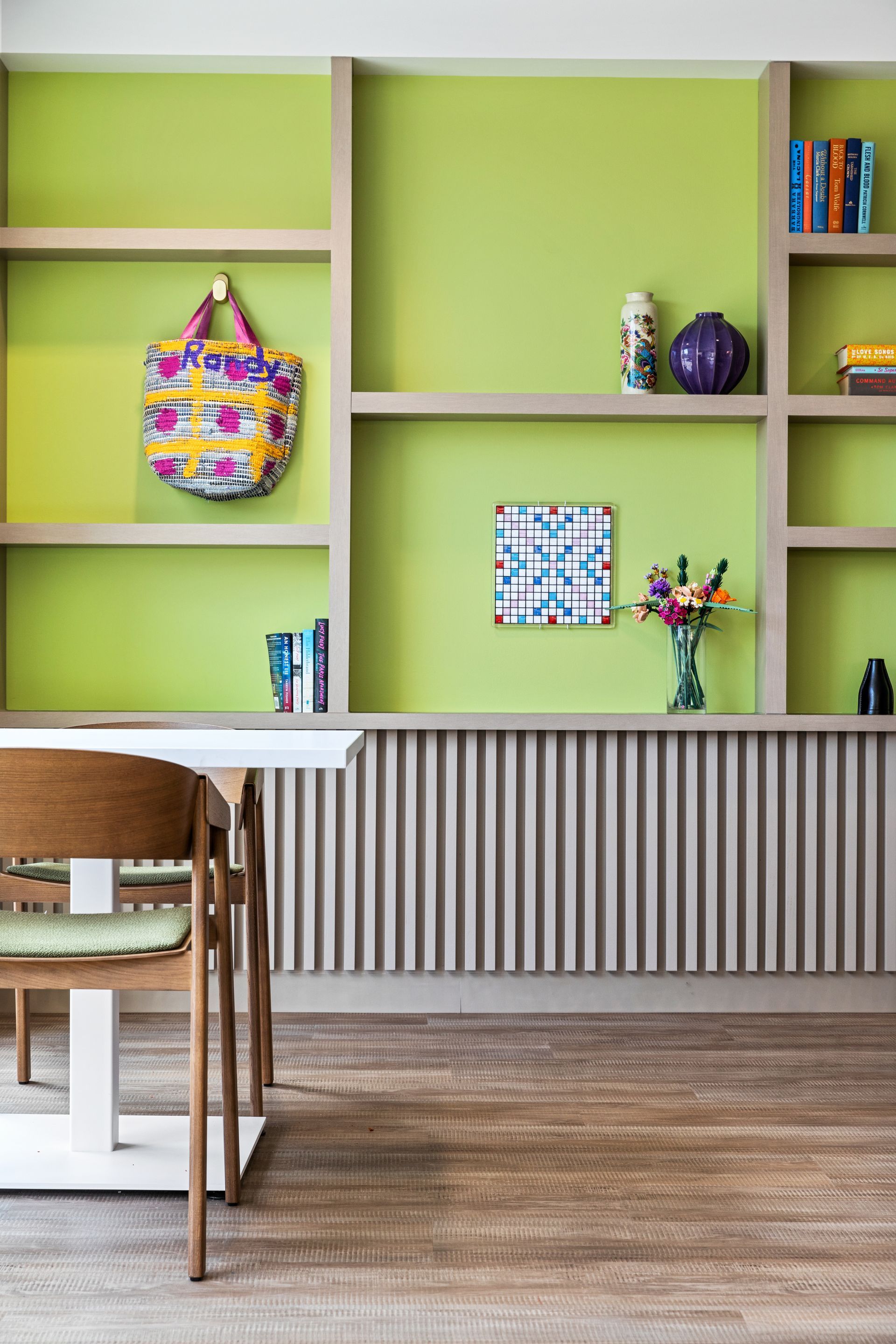 There is a table and chairs in the room with green walls.