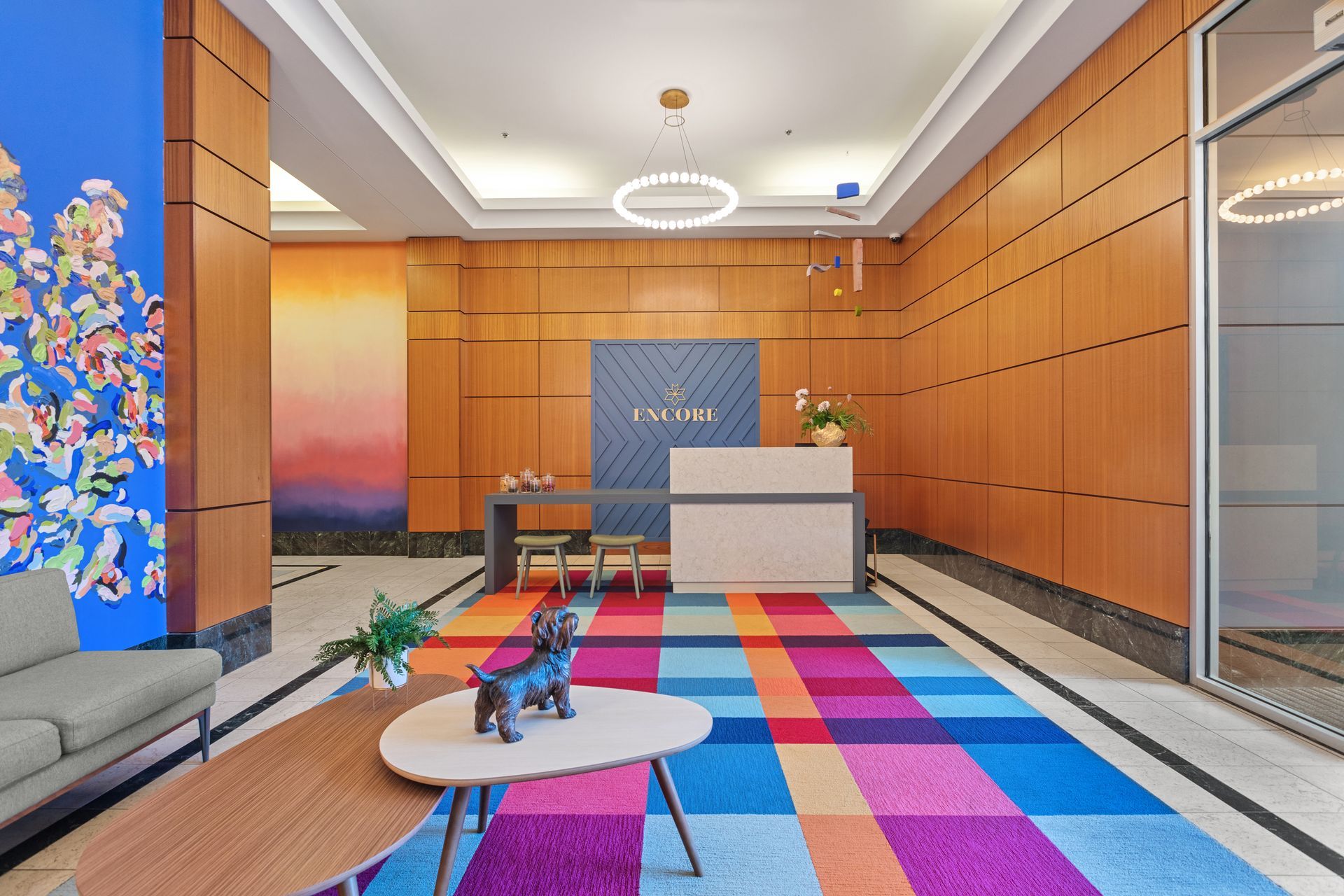 A lobby with a colorful rug and a reception desk