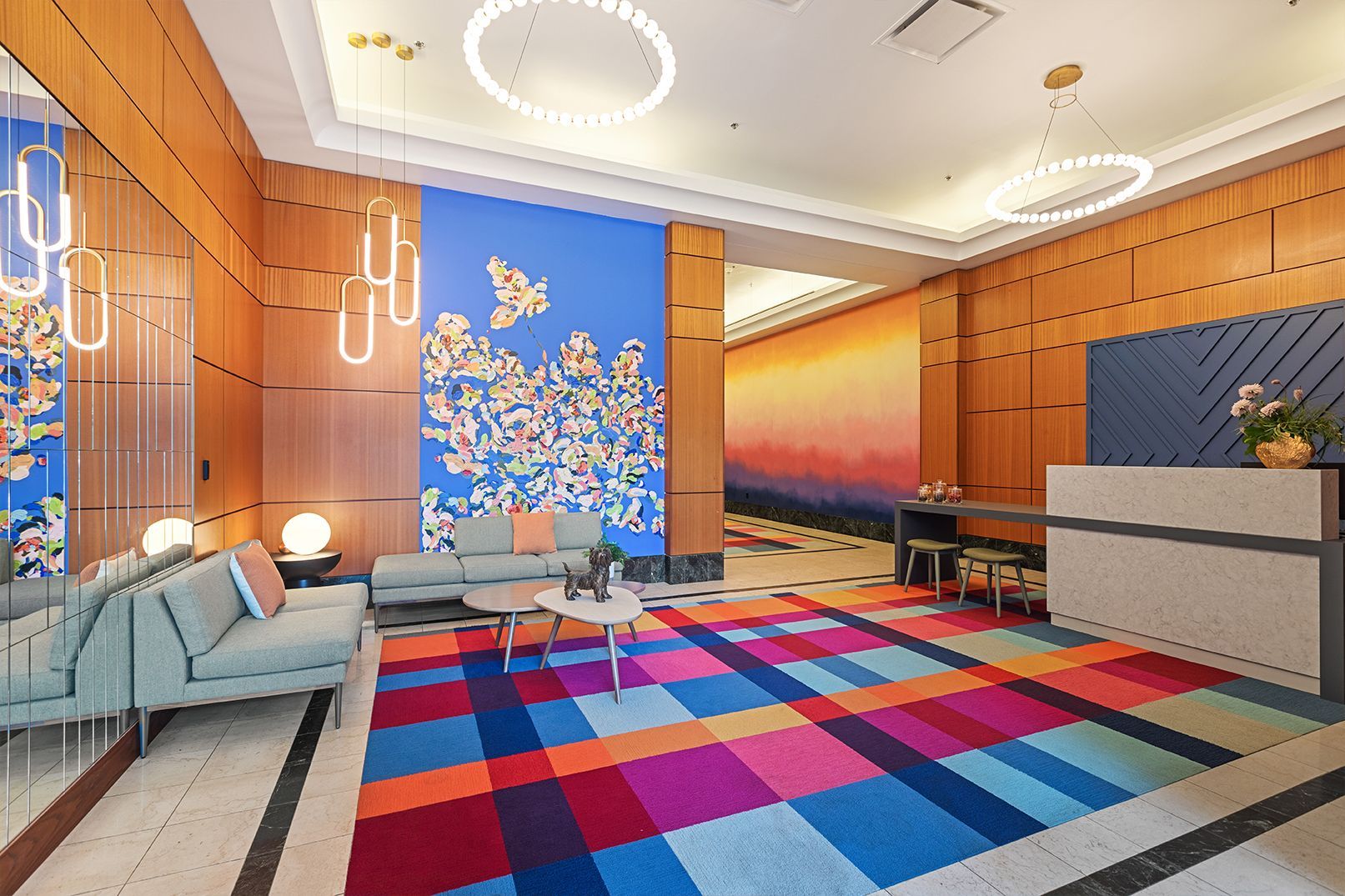 A lobby with a colorful rug and a couch.
