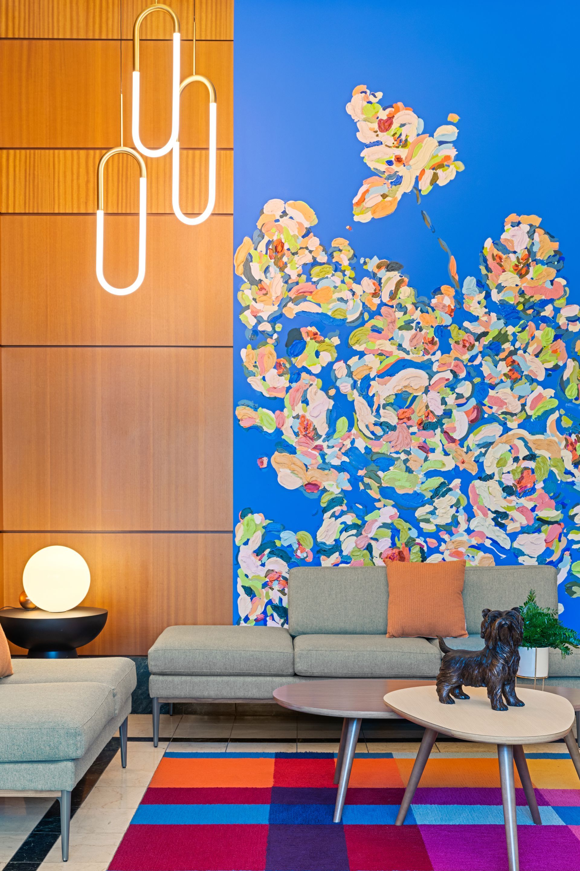 A living room with a couch , coffee tables , and a colorful rug.