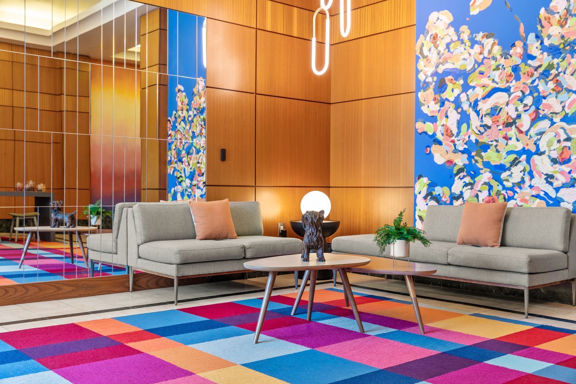 A living room with couches , tables , and a colorful rug.