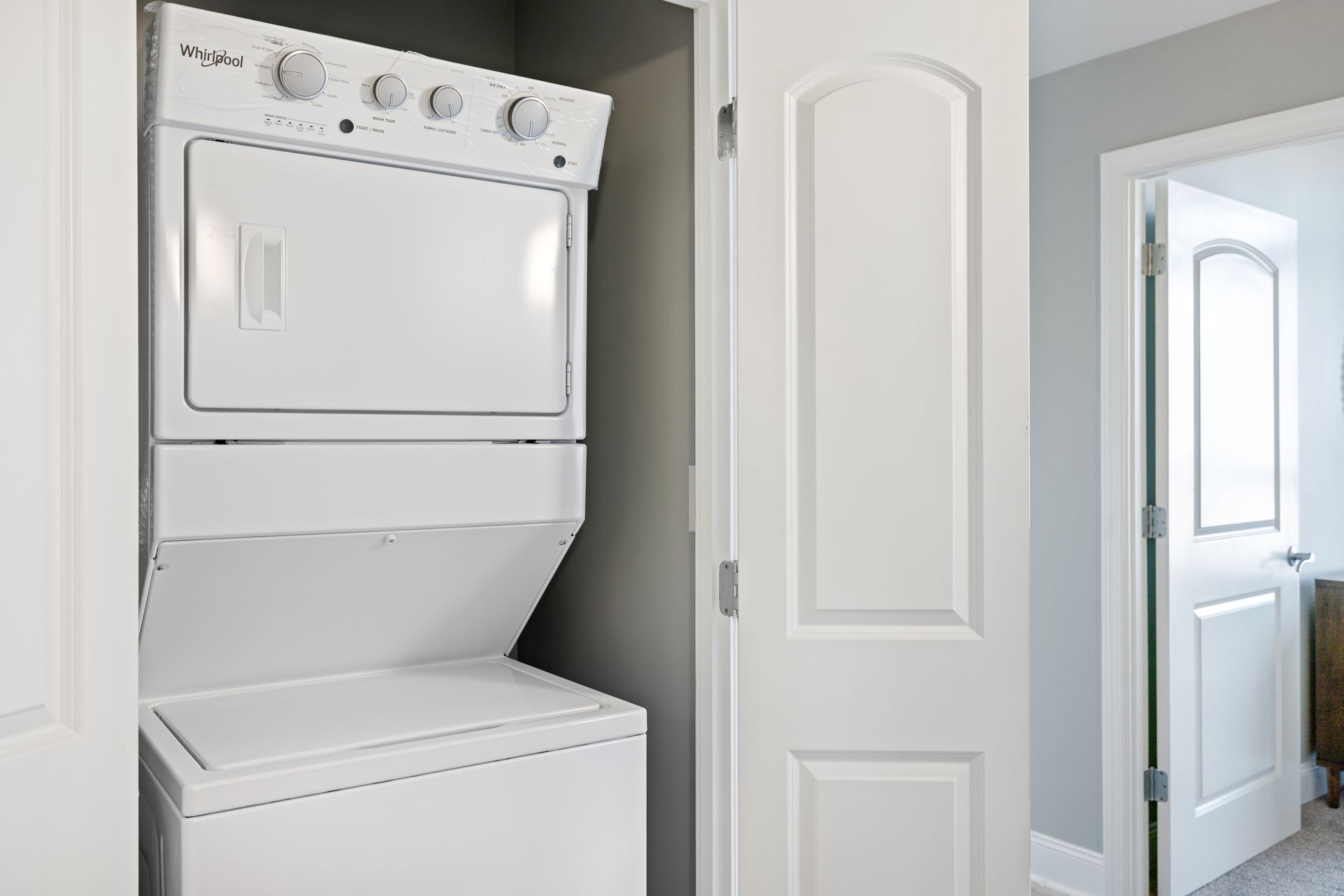 A washer and dryer are stacked on top of each other in a closet.