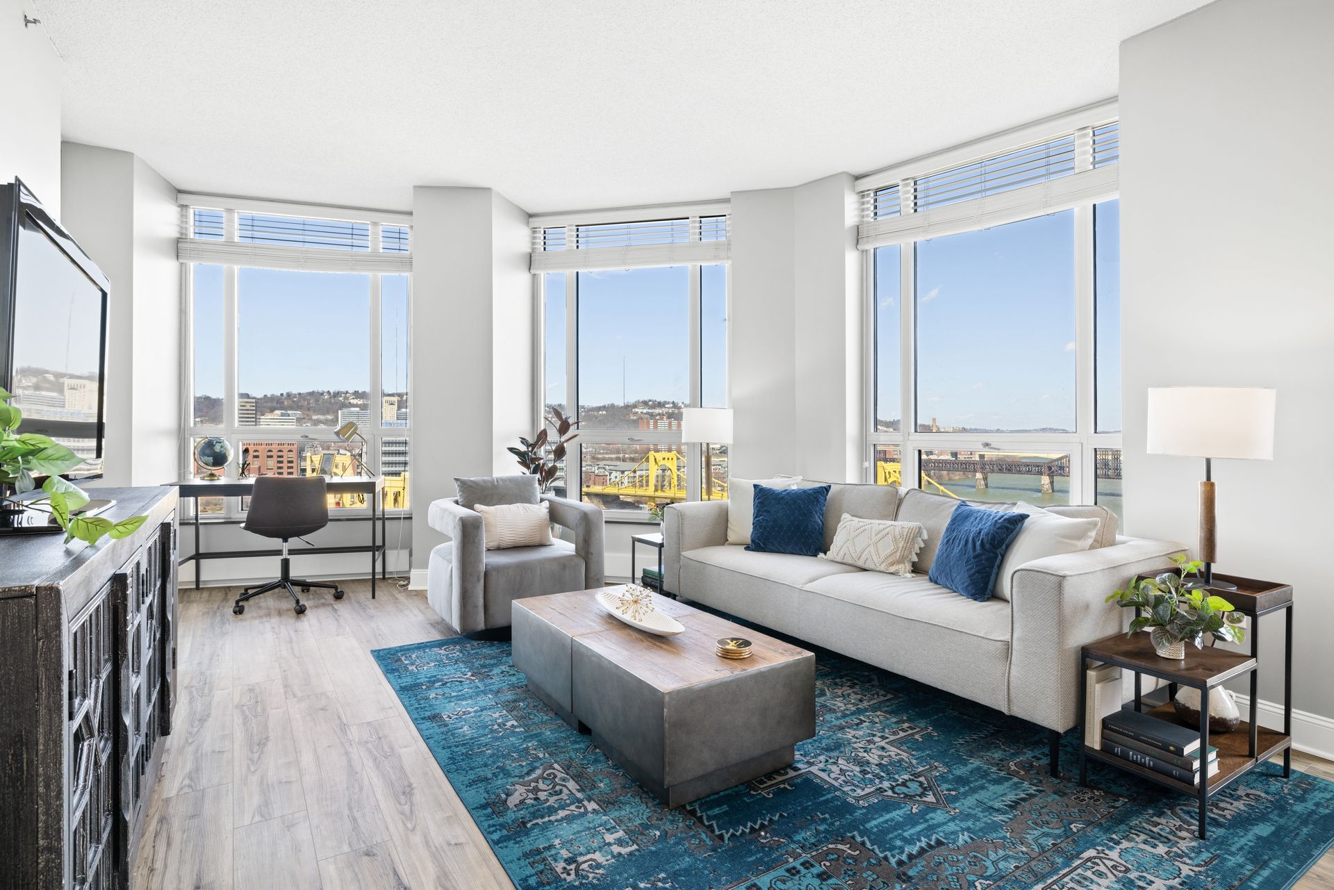 A living room with a couch , chair , coffee table and television.