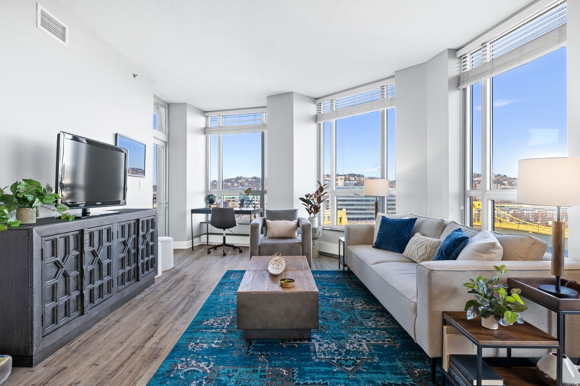 A living room with a couch , table , chairs , and a television.