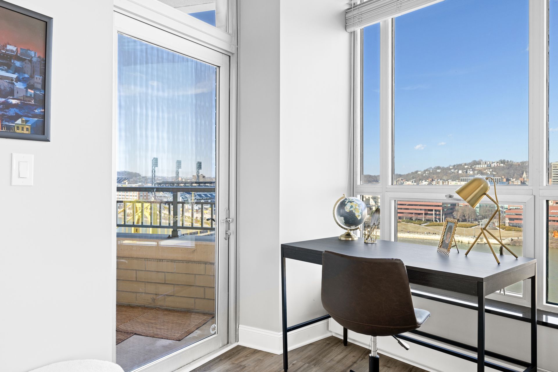 A room with a desk and chair in front of a window.