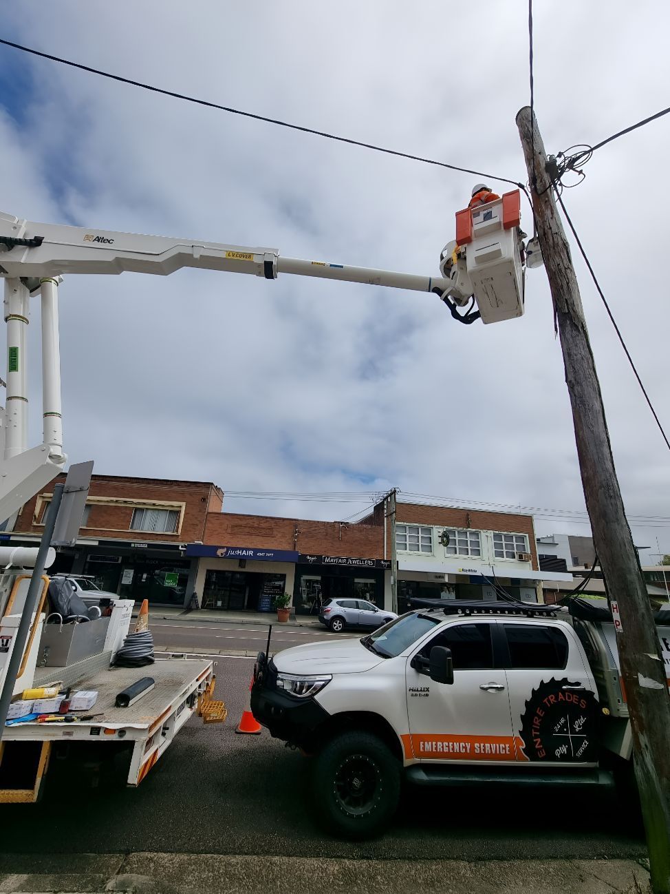 A White Truck Is Parked Next To A Pole With A Crane On Top Of It — Entire Power Solutions In Maitland, NSW