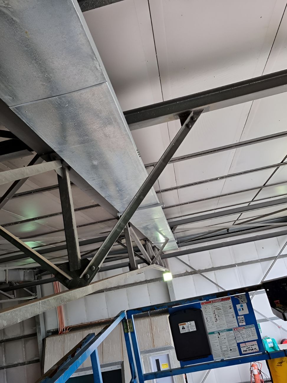 A Large Metal Pipe Is Hanging From The Ceiling Of A Building — Entire Power Solutions In East Maitland, NSW