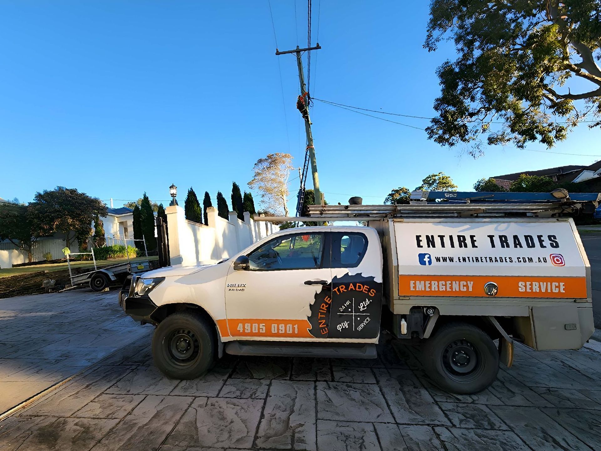 A Work Ute Is Parked On A Paved Driveway— Entire Power Solutions In Beresfield, NSW
