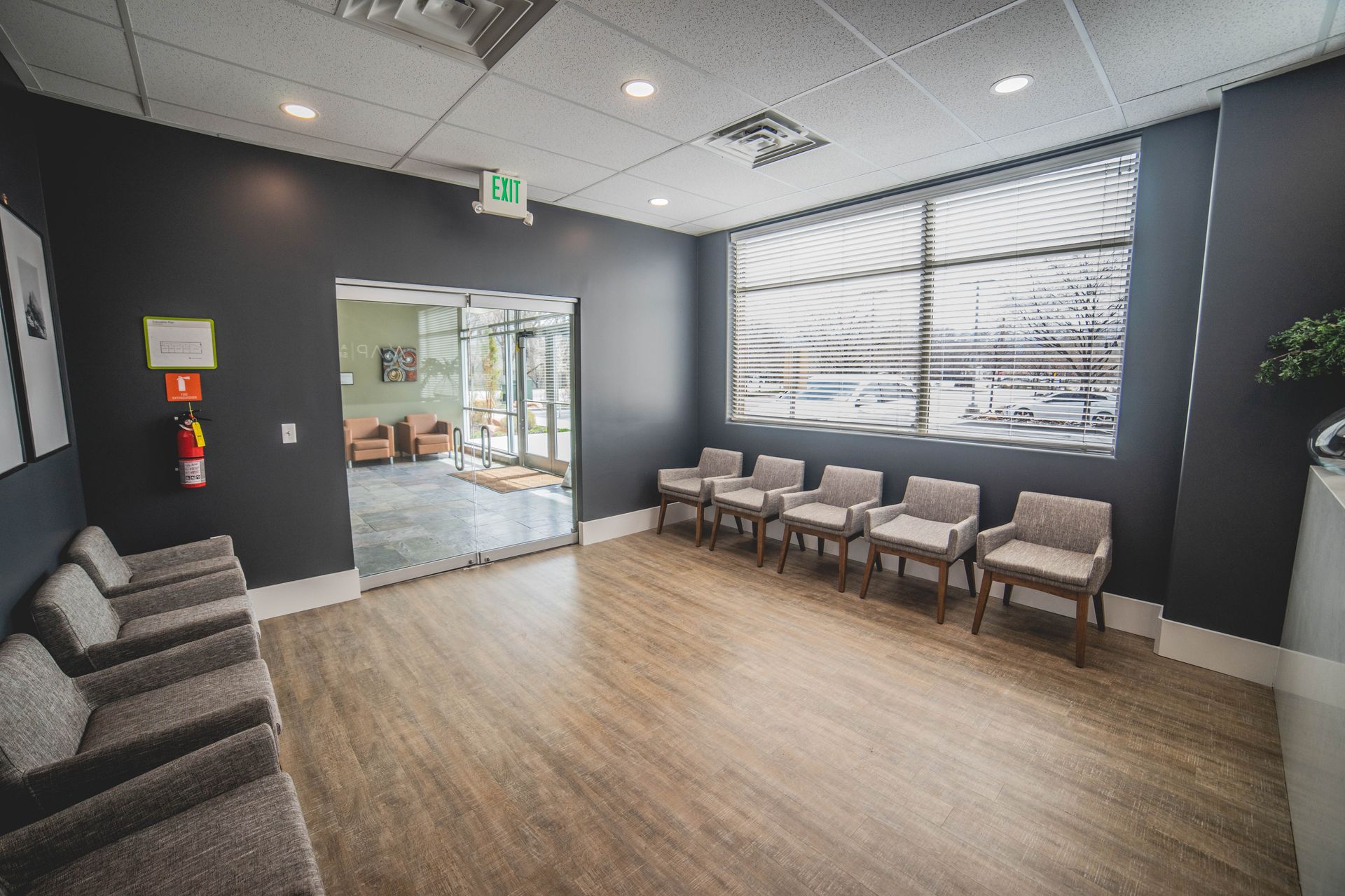 A waiting room with a lot of chairs and a large window.