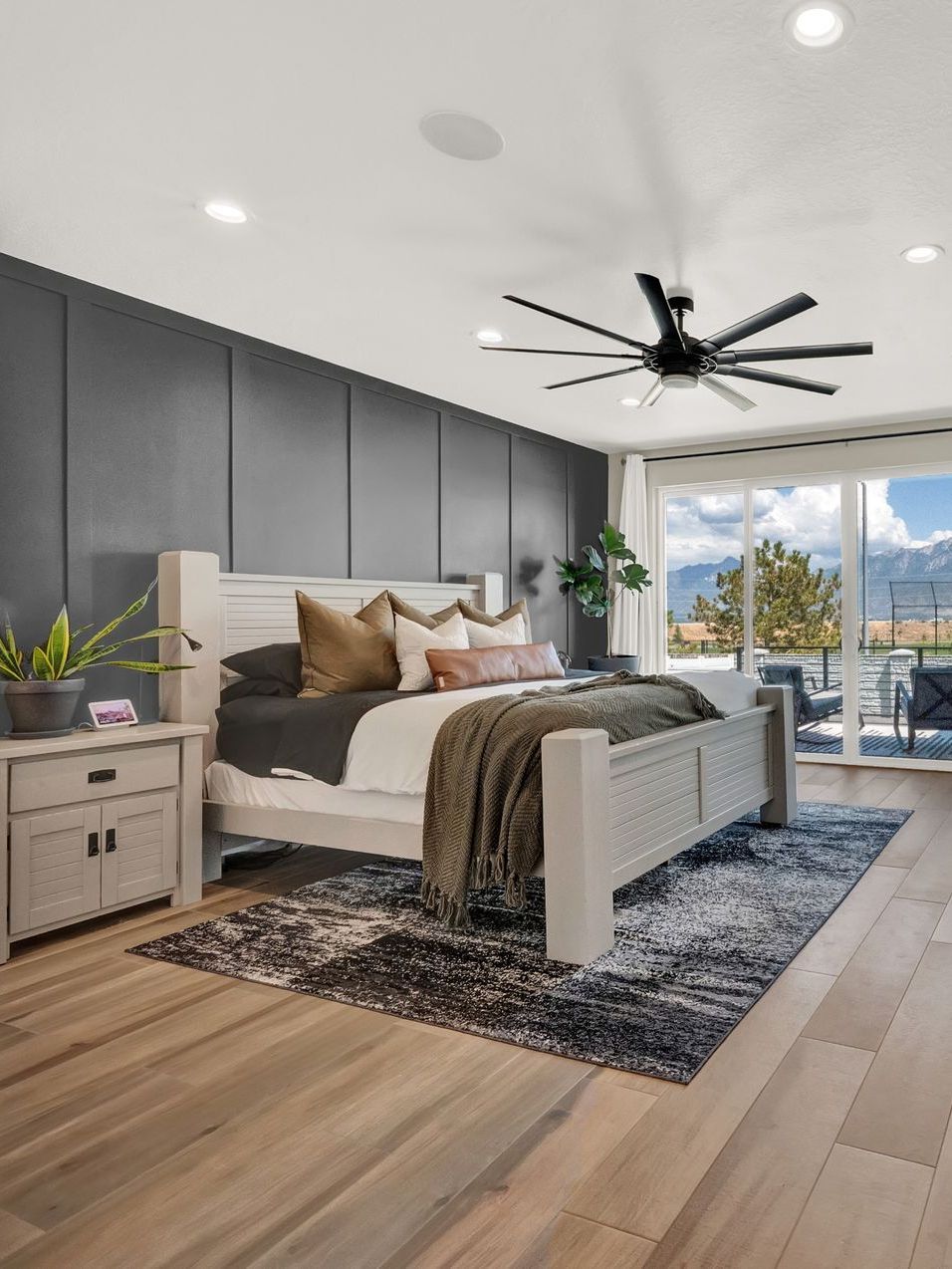 A bedroom with a large bed and a ceiling fan.