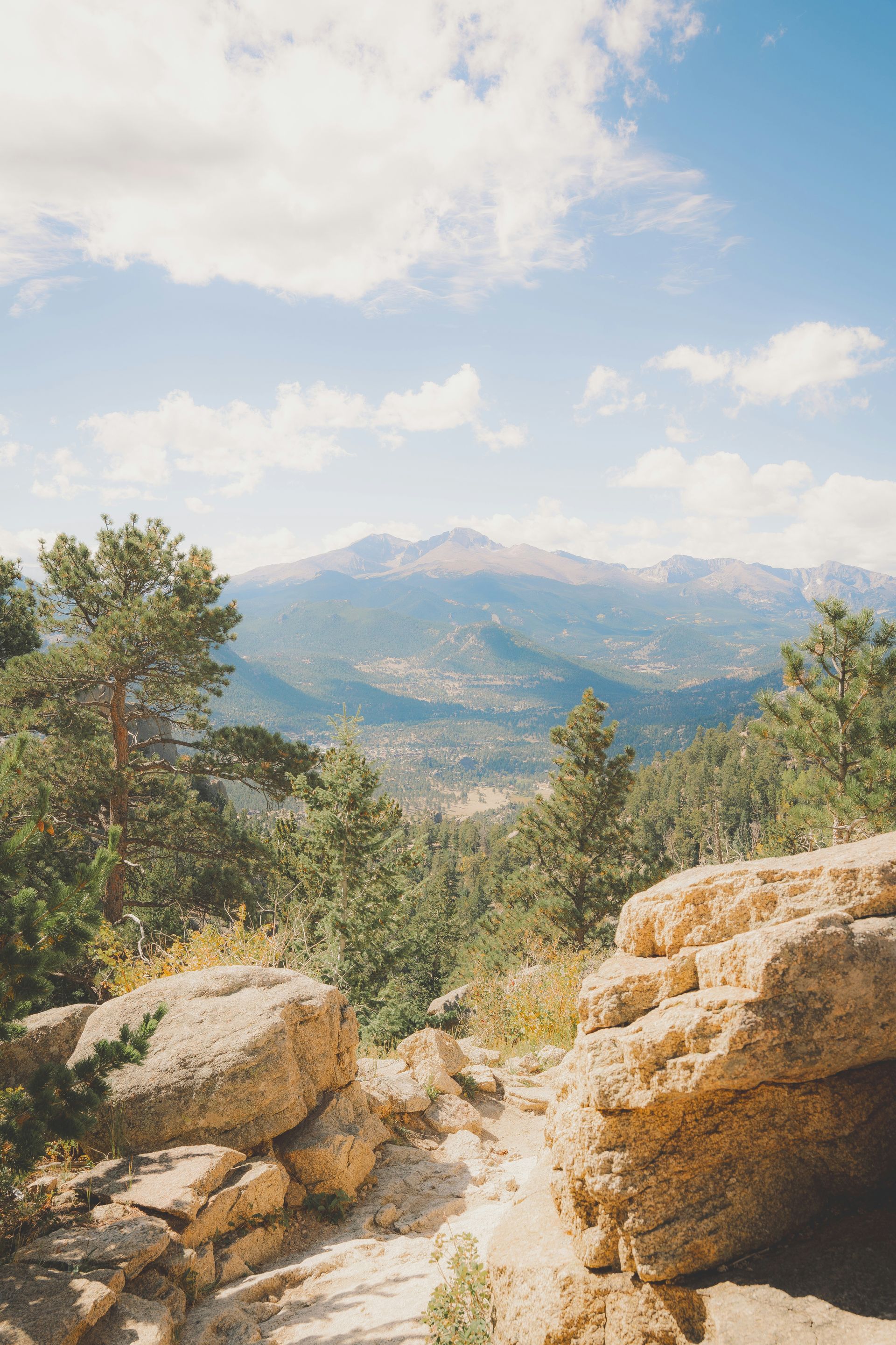 A view of a mountain range from the top of a rocky hill.