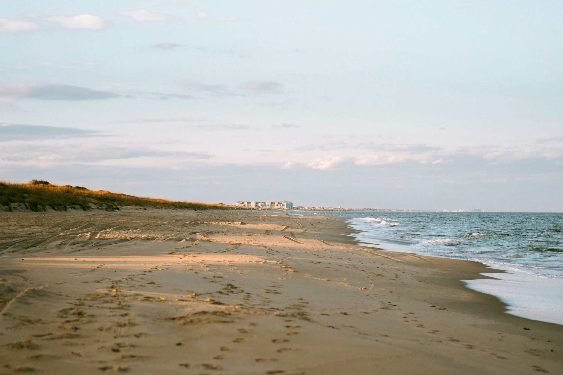 A beach with a city in the background and a city in the distance.