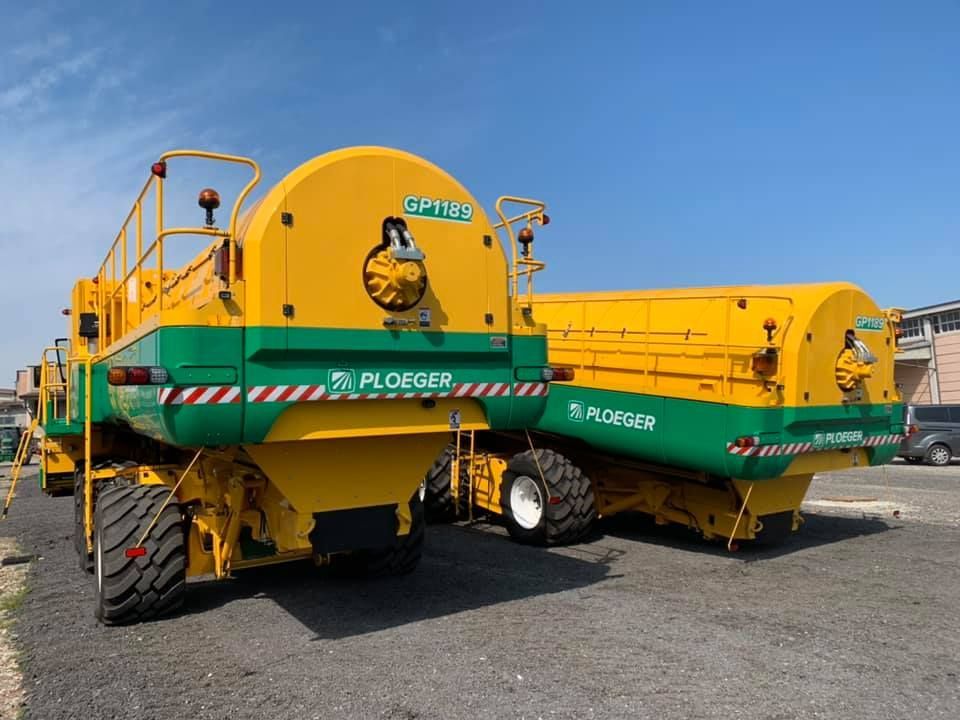 Due trattori gialli e verdi sono parcheggiati uno accanto all'altro in un parcheggio.