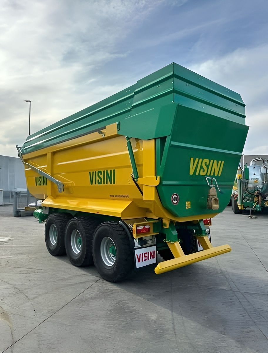 Un camion con cassone ribaltabile giallo e verde è parcheggiato in un parcheggio.
