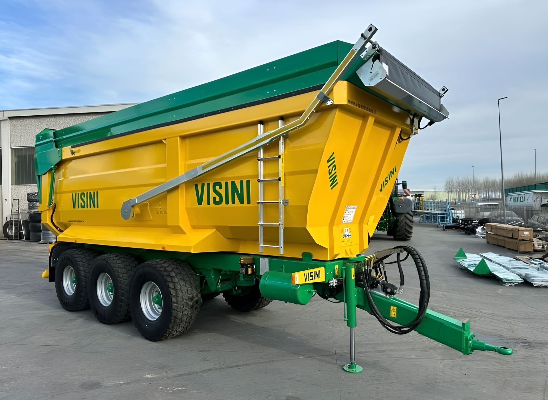 Un camion con cassone ribaltabile giallo e verde è parcheggiato in un parcheggio.
