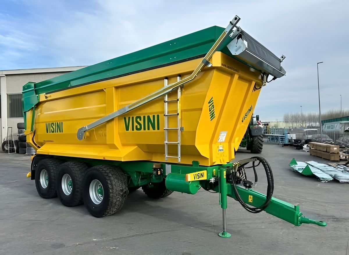 Un camion con cassone ribaltabile giallo e verde è parcheggiato in un parcheggio.