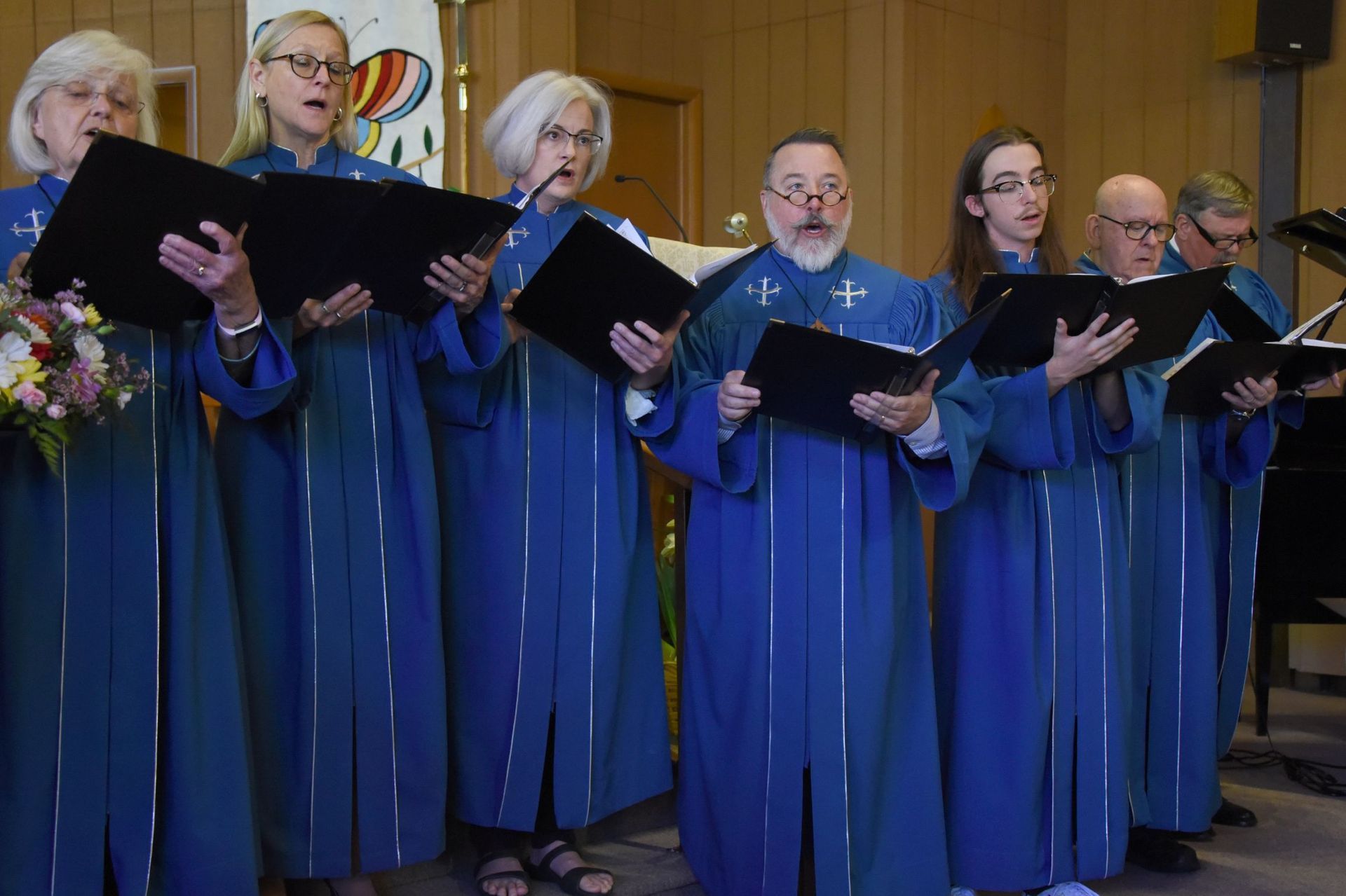 A group of people in blue robes singing in a church
