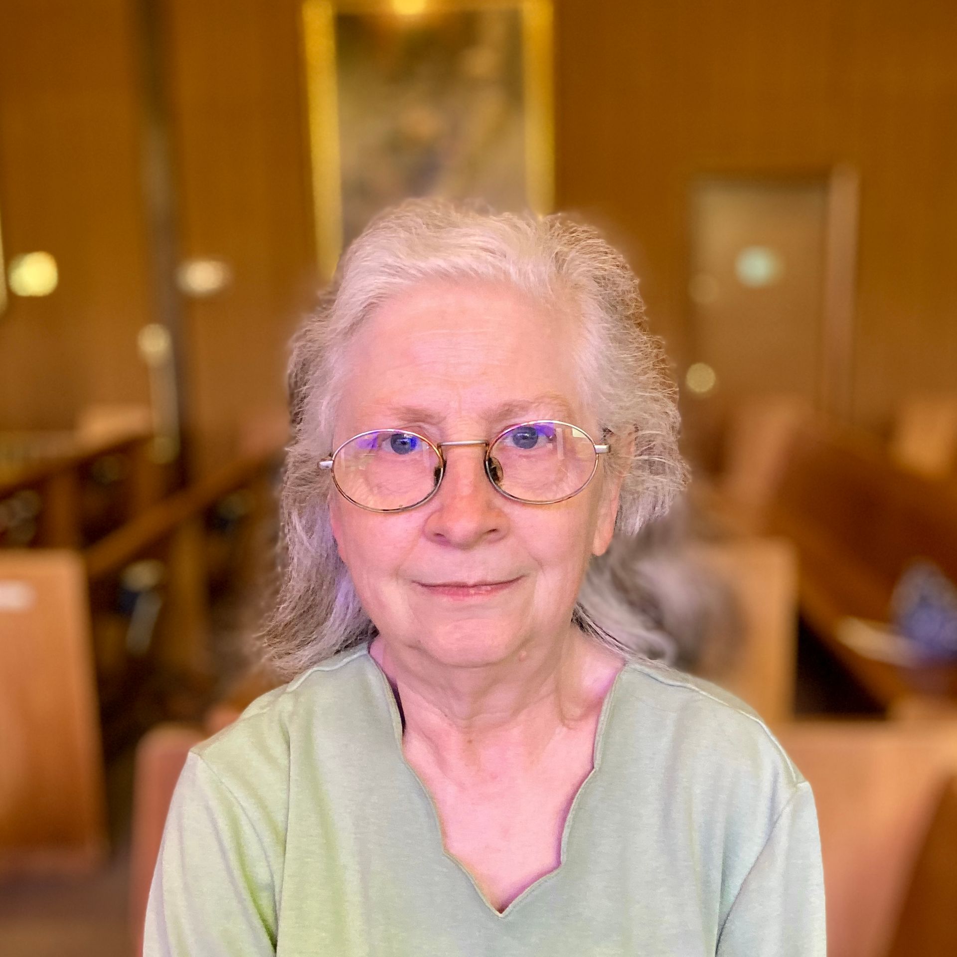 An older woman wearing glasses and a green shirt