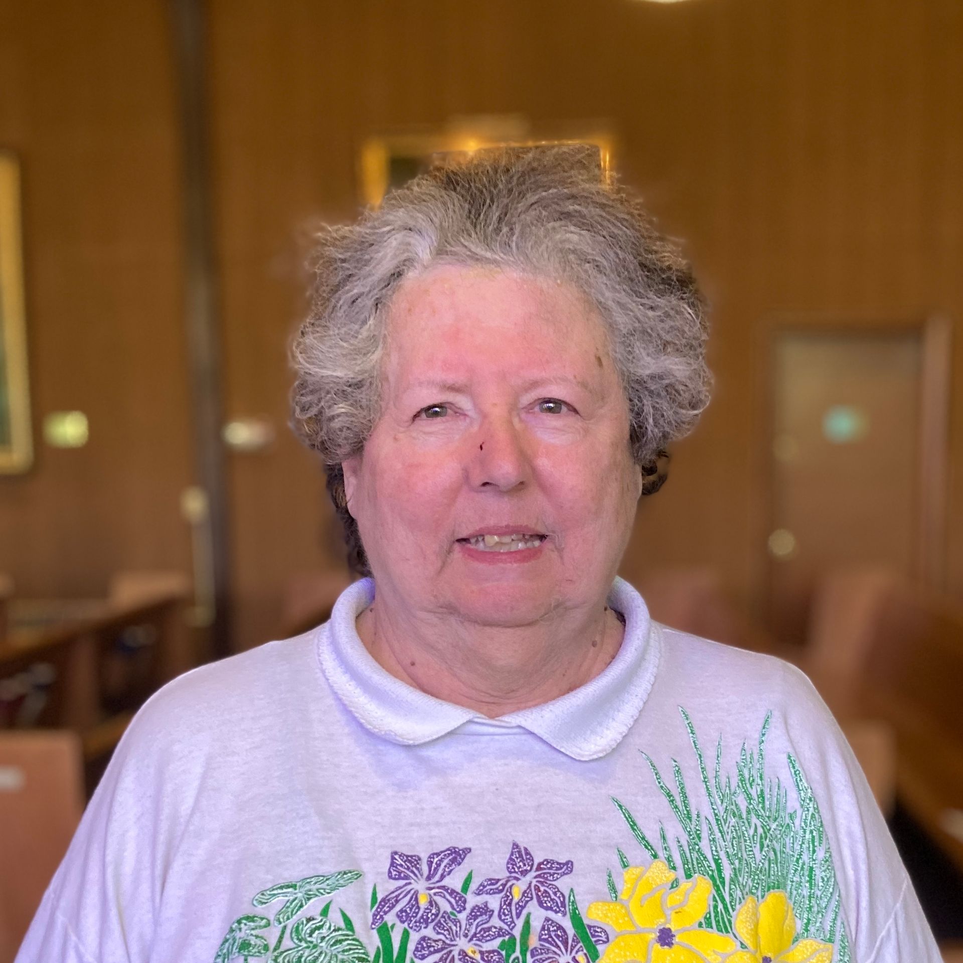 A woman wearing a white shirt with flowers on it