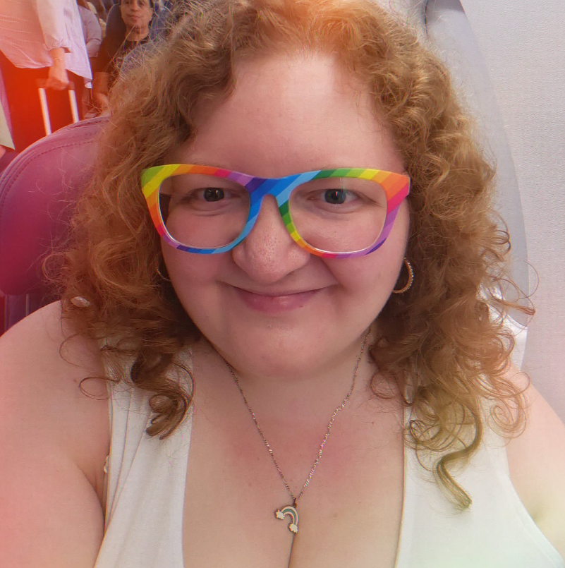 A woman wearing a white tank top and rainbow glasses