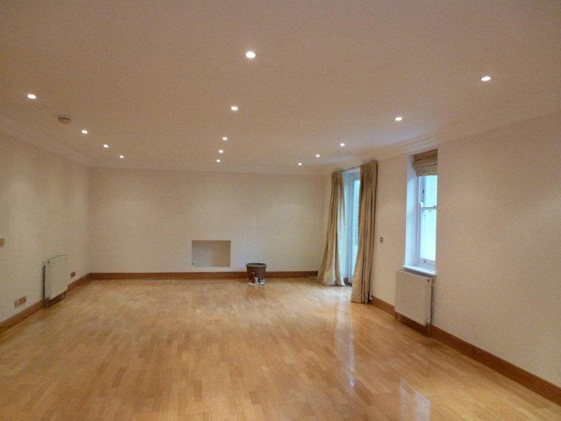 large empty room with wooden floor and spotlights
