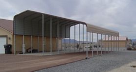 A large metal structure is sitting on top of a gravel road.