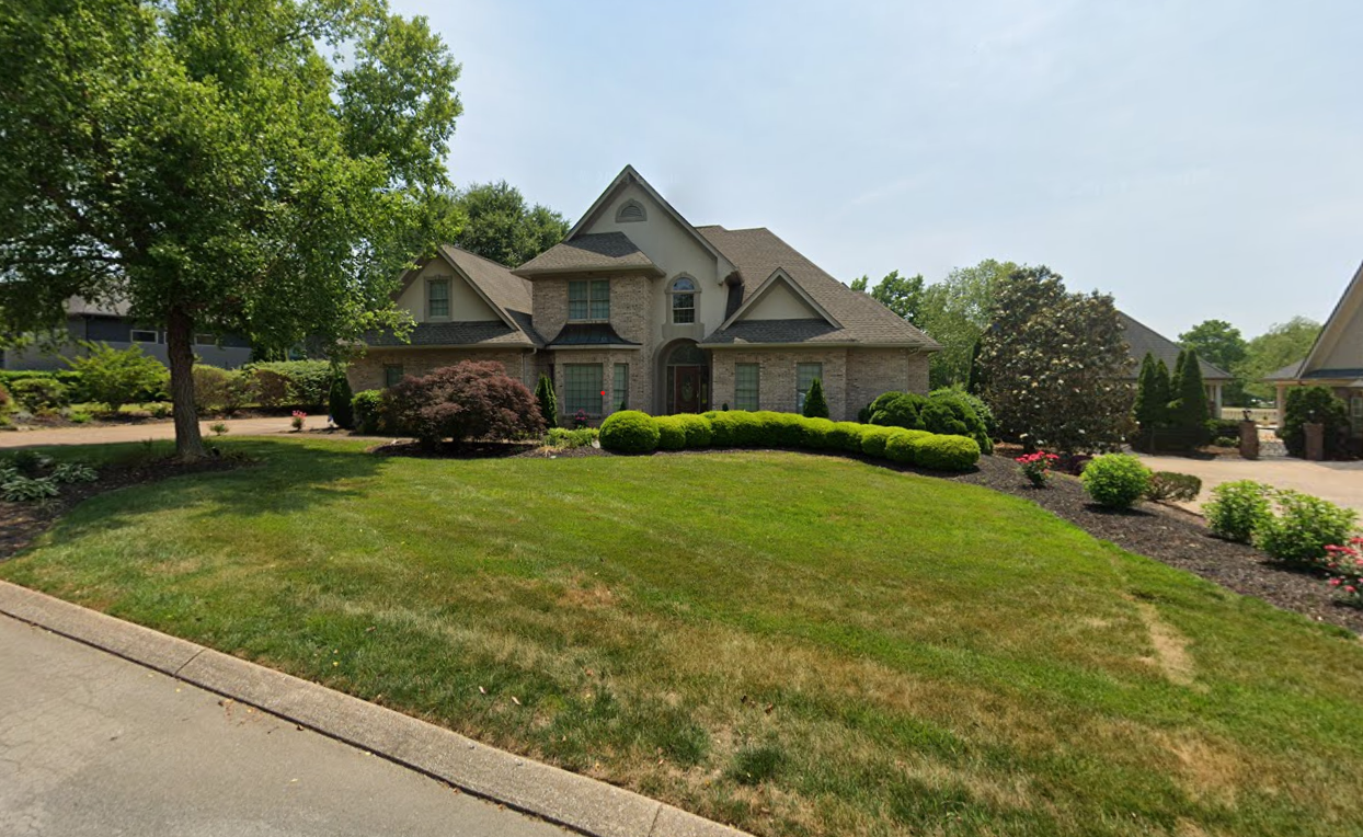 A large house with a lush green lawn in front of it.