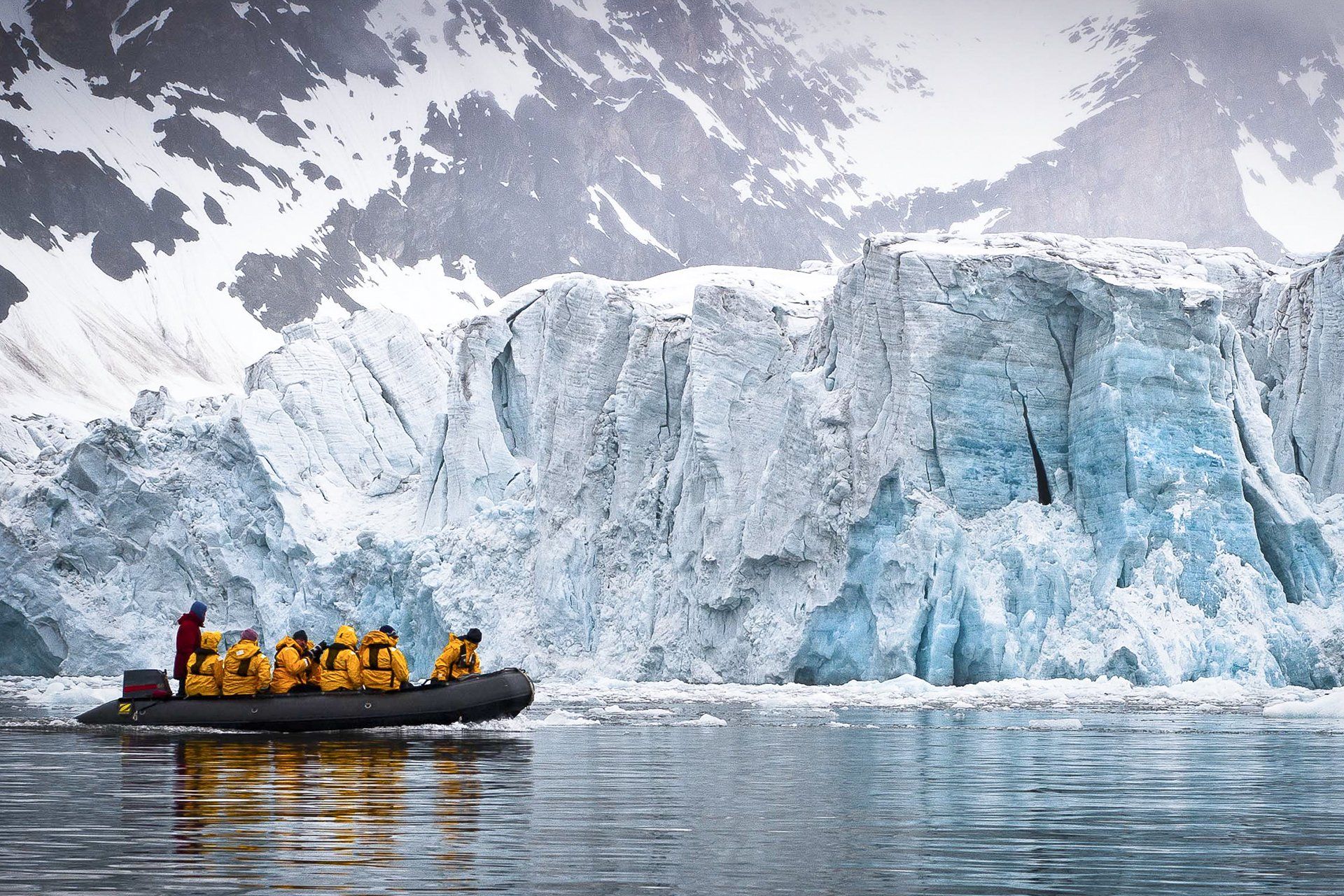 Boat in Icelandic sea heading towards huge iceberg glacier
