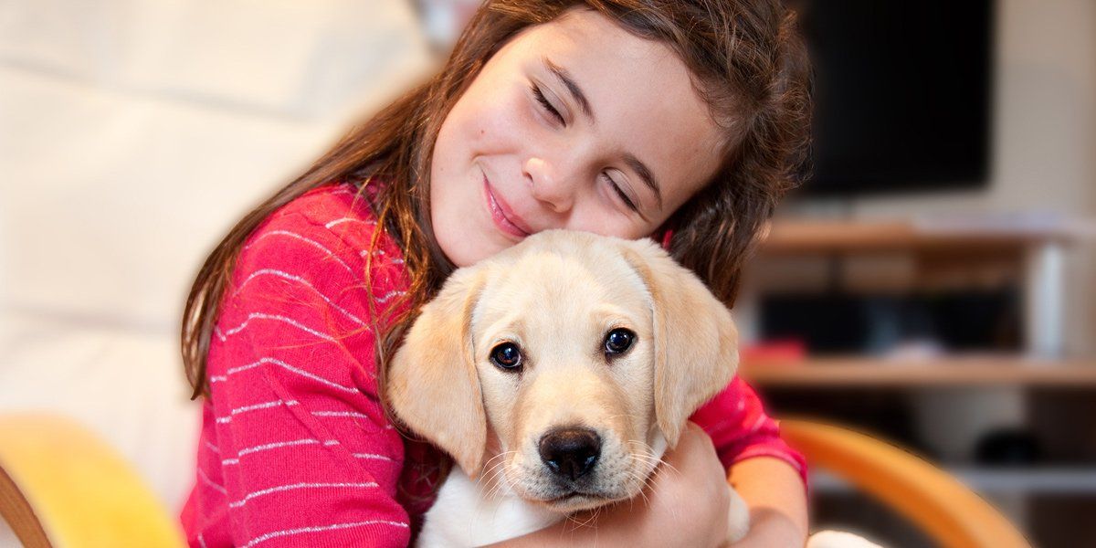 young girl hugging dog