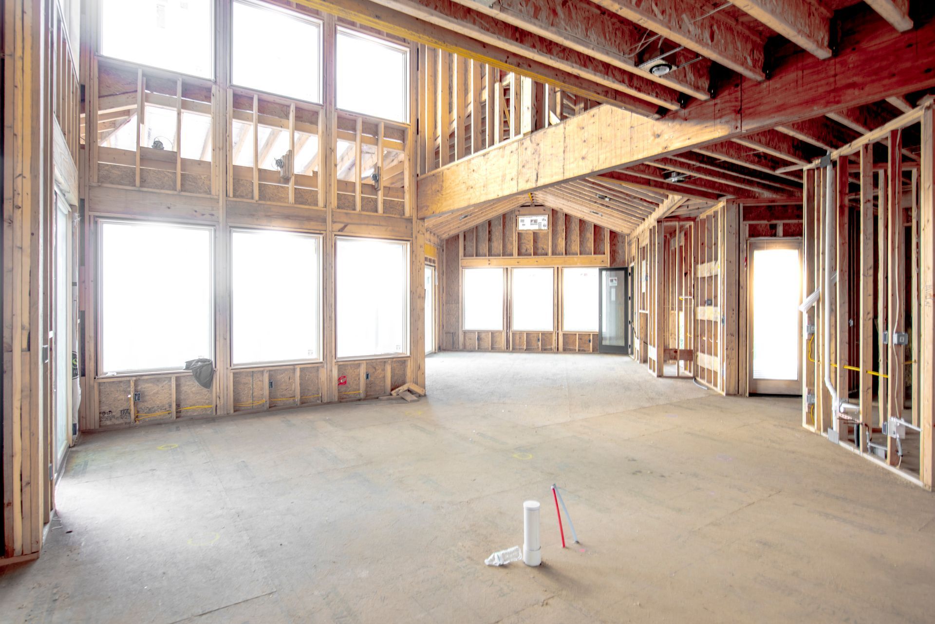 A wooden bench is in a hallway next to a window.