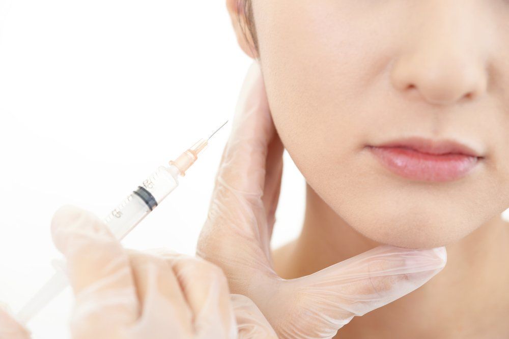 Woman Getting Cosmetic Injection In Her Cheek — Cosmetic Clinic in Wollongong