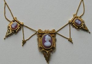 Gold necklace with three oval cameos in purple and white, connected by chains.