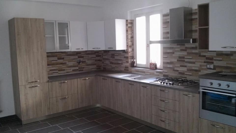 cucina con armadi e cassetti in legno chiaro